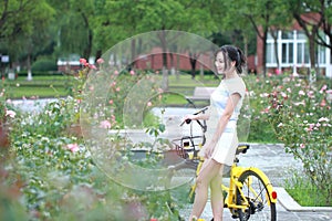 Young beautiful, elegantly dressed woman with Sharing bicycle. Beauty, fashion and lifestyle