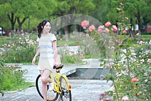 Young beautiful, elegantly dressed woman with Sharing bicycle. Beauty, fashion and lifestyle