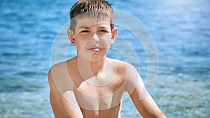 Young beautiful european caucasian boy plays on beach sand pebble sea Montenegro Boka kotorska