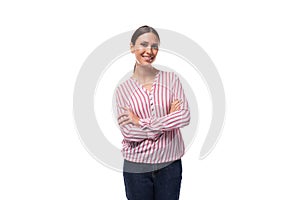 young beautiful european woman with black hair gathered in a ponytail is dressed in a striped blouse on a white