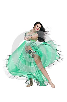 Young beautiful exotic eastern women performs belly dance in ethnic green dress. Isolated on white background