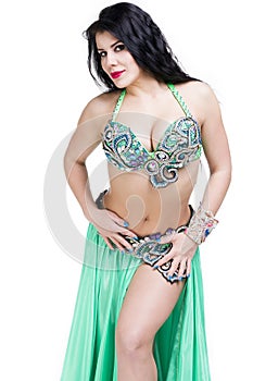 Young beautiful exotic eastern women performs belly dance in ethnic green dress. Isolated on white background