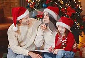 Young beautiful family writing letter to Santa together