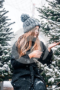 Young beautiful fashion girl is enjoying her time through winter holiday in Christmas evening, Moscow, Tverskaya Square