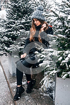 Young beautiful fashion girl is enjoying her time through winter holiday in Christmas evening, Moscow, Tverskaya Square