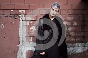 Young beautiful fashion girl shooting outdoors near brick wall at home