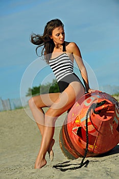 Young beautiful fashion model in onepiece stripped swimsuit