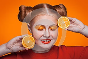 Young beautiful fashion model with orange. studio shot.