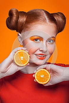 Young beautiful fashion model with orange. studio shot.