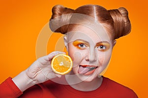 Young beautiful fashion model with orange. studio shot.