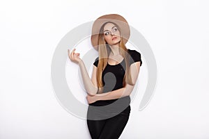 Young beautiful fashion model in women black t-shirt trendy hat posing in studio against white background