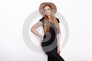 Young beautiful fashion model in women black t-shirt trendy hat posing in studio against white background