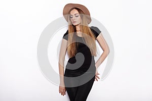 Young beautiful fashion model in women black t-shirt trendy hat posing in studio against white background