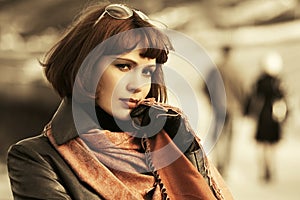 Young beautiful fashion woman in black leather coat and brown scarf