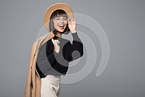 Young beautiful fashionable woman wearing stylish eyeglasses, fake fur coat, hat. Female fashion, beauty concept. Outdoor. Close