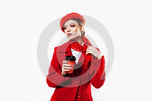 young beautiful fashionable woman wearing stylish winter red coat, silk scarf, red beret on a white in studio. Copy