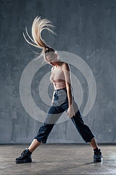 Young beautiful female dancer is posing in the studio