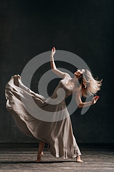 Young beautiful female dancer is posing in the studio