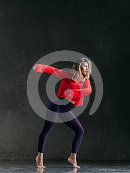 Young beautiful female dancer is posing in the studio