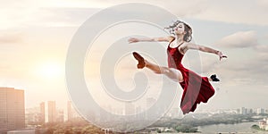 Young and beautiful female dancer in a red dress