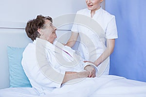 Young beautiful female doctor and senior patient at hospital