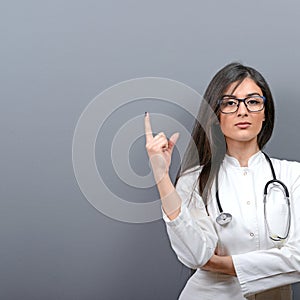 Young beautiful female doctor showing blank area