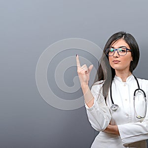 Young beautiful female doctor showing blank area