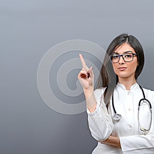 Young beautiful female doctor showing blank area