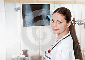 Young beautiful female doctor in white coat with roentgen in hands