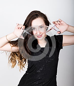 Young beautiful female Hairdresser posing with scissors