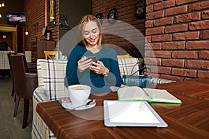 Young beautiful female holding mobile phone