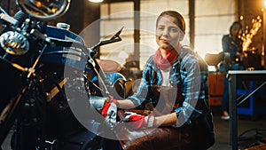 Young Beautiful Female Mechanic is Working on a Custom Bobber Motorcycle. Talented Girl Wearing a