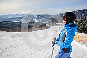 Young beautiful female skier on the middle of ski slope