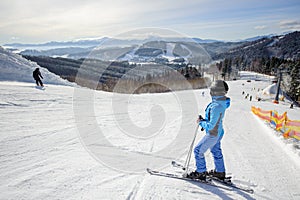 Young beautiful female skier on the middle of ski slope