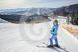 Young beautiful female skier on the middle of ski slope