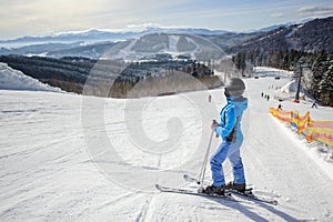 Young beautiful female skier on the middle of ski slope