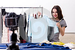 The young beautiful female tailor recording video for her blog