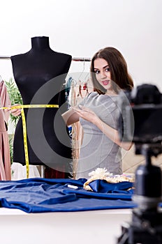 The young beautiful female tailor recording video for her blog