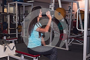 Young beautiful and fit sport woman in fitness clothes drinking water tired during training workout