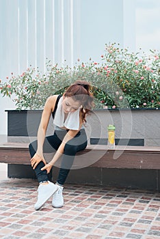 Young beautiful and fit sport woman looking at mobile phone internet app tracking performance after running workout sitting on