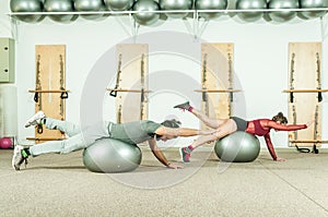 Young beautiful fitness couple workout extreme acrobatic exercise on the ball as preparation for the competition, selective focus