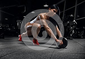 Young beautiful fitness girl posing in the gym