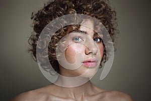 Young beautiful freckled girl with curly hair and clean makeup, selective focus