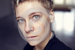 Young beautiful freckles woman face portrait with healthy skin and short hair, green eyes.