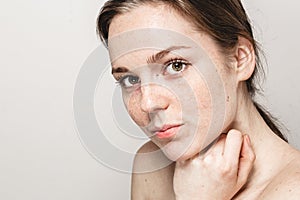 Young beautiful freckles woman face portrait with healthy skin