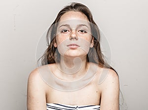 Young beautiful freckles woman face portrait with healthy skin