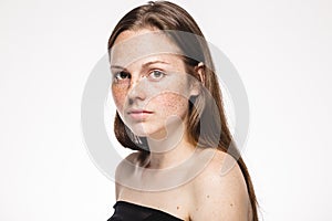 Young beautiful freckles woman face portrait with healthy skin