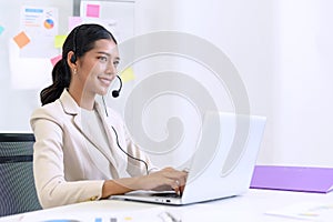Young beautiful friendly operator woman with headset working in a call center. customer service pay attention and talking to