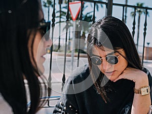 Young and beautiful friends having a refreshing drink on a terrace of a day bar