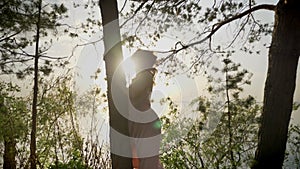 Young beautiful ginger smiling girl on beach in forest standing near tree, nature, silhouette, looking at camera 50 fps